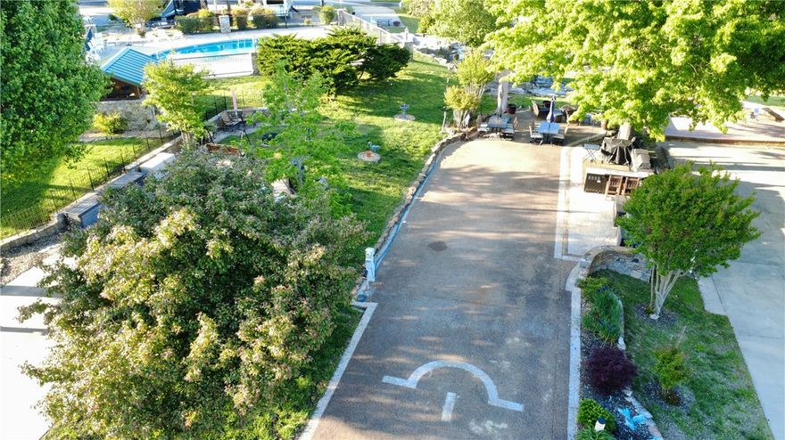 Experience luxury lakeside living with this premium RV lot on beautiful Table Rock Lake! Designed for comfort and convenience, this spacious lot easily accommodates a 45-foot coach and offers plenty of additional parking for guests or golf carts. Enjoy top-tier amenities, including access to a community pool and well-maintained bath house, perfect for relaxing after a day on the water. With easy lake access just steps away, you can spend your days boating, fishing, or simply soaking in the stunning surroundings. Entertain in style with your own outdoor kitchen—ideal for hosting friends and family or enjoying quiet evenings under the stars or around the campfire. Whether you're looking for a weekend getaway or a seasonal retreat, this luxury RV lot combines upscale features with the natural beauty of Table Rock Lake for the ultimate outdoor living experience  **Furnishings do not convey but may be negotiated at additional cost.