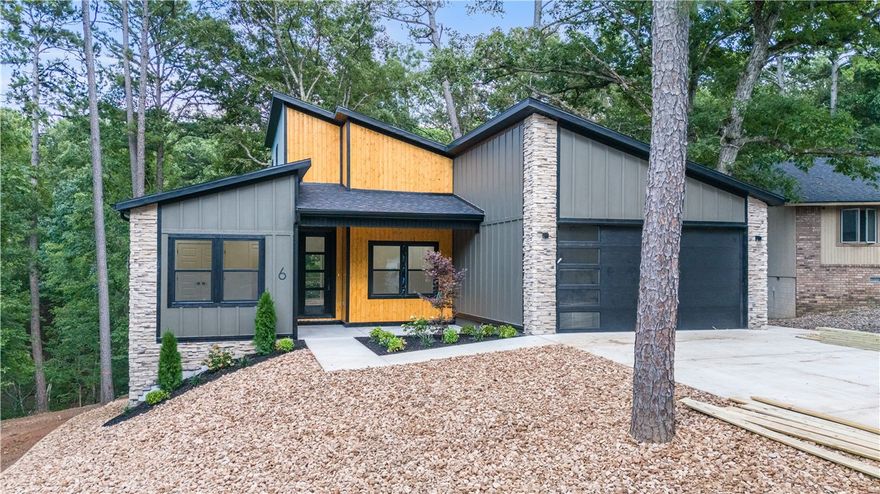 Contemporary living and architecture at its finest on a cul-de-sac lot just off the Back 40 Trail. Split floor plan including 3 bed, 2 bath home with an office all set in modern elegance highlighted by vaulted ceilings, clean lines and open floor plan with tons of natural light. This exceptional home also features a full appliance package including the refrigerator and washer/dryer. High end finishes throughout, especially in the kitchen with quartz counters and stainless appliances as well as huge shower and soaker tub in the primary ensuite. Get ready to entertain, relax, and enjoy life in a setting that feels both surrounded by nature yet close to everything. Enjoy an expansive poly-wood deck, inviting front porch and huge hard-scape yard with cool fire pit area (included). . All this set in the one of the most desirable areas of Bella Vista close to trails, shopping and short drive to conveniences including Bentonville.