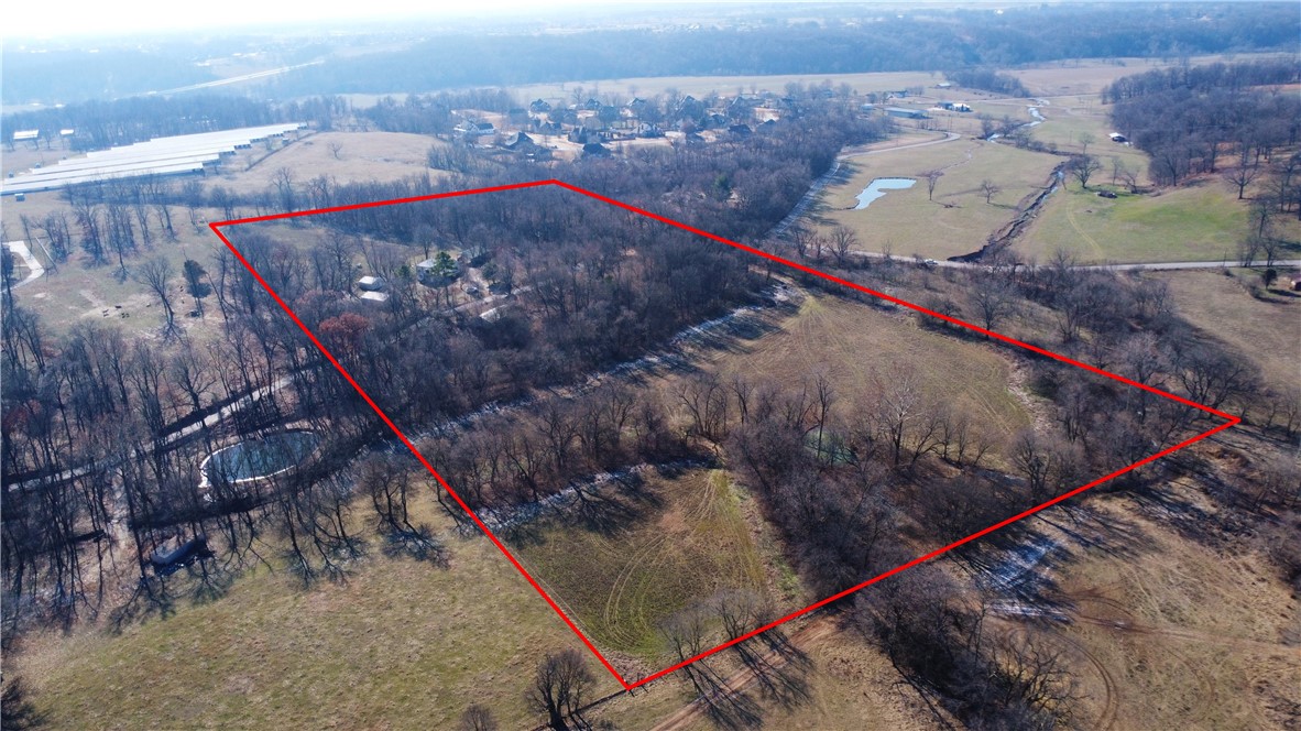 Located in the heart of Northwest Arkansas this property has all kinds of potential. Easy access to I-49. The property consists of 20 (+/-) acres. Would make a nice estate property or could be developed into estate lots. Lots of privacy and room to spread out. The value is in the land. There is currently an older farm house on the property along with two shops and a pole barn. There is a well on the property. The property is in the city limits of Springdale with a Lowell mailing address. Rogers School District.