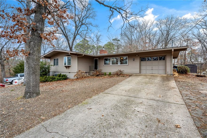 PRICE IMPROVED! Discover a REMARKABLY UPDATES Mid-Century Modern charm in this Bella Vista home! The spacious, open living area features a striking stone wood-burning fireplace. A modern kitchen boasts a large island, sleek fixtures, and quartz countertops. The primary bath is a spa-like retreat with a soaking tub and separate shower. Offering 3 bedrooms, an office, and 2.5 baths, this home also includes a sunroom with peaceful views of the flat, wooded backyard and a heated office with a mini-split for year-round comfort. Enjoy upgrades like high-efficiency HVAC, Anderson windows, Pergo laminate flooring, and a new mini-split. The backyard storage building serves as a versatile workshop. Please note, the home is on a 2-bedroom septic system. Seller will provide a new modern garage door with an acceptable offer!