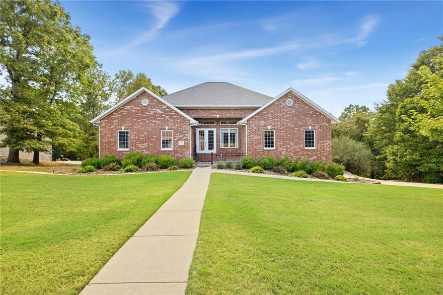 BOAT SLIP SOLD SEPARATELY. Discover this spacious 4,277 sq ft home in The Preserve subdivision, perfectly situated near Beaver Lake yet just minutes from downtown Rogers. Nestled on a private, wooded 1.30-acre lot, this all-brick home offers 4 bedrooms, 3 full baths, multiple living areas & exceptional storage throughout. Inside, you’ll find hardwood floors, custom cabinetry, crown molding & large walk-in closets. The open kitchen features quartz countertops, large island and ss appliances, flowing seamlessly into a hearth room w/gas log fireplace & built-ins. The main-level primary suite boasts his/hers closets, deck access & a spa-like bath w/dual vanities, jetted tub, & walk-in shower. The walk-out lower level includes a large living area, wet bar, full bath, oversized bedroom, flex space w/safe, & access to a covered patio. Outdoor living is enhanced with both upper & lower-level spaces to enjoy the natural setting. Additional features include two laundry rooms, 4-car garage (2 up/2 down), and new roof (2025).