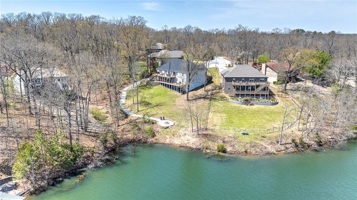 Welcome to your own slice of lakefront paradise on beautiful Lake Brittany in Bella Vista. This 5-bedroom, 3-bath home offers the perfect blend of relaxation and functionality with lake access directly from the property—just steps to the water for kayaking, fishing, or simply soaking in the view. Designed for comfort and flexibility, the home features two full kitchens, 2 living rooms, and 2 laundry rooms. Fantastic layout, ideal for guests, entertaining, or multi-generational living. Step outside to enjoy two expansive decks overlooking the lake, perfect for outdoor dining, morning coffee, or evening gatherings. Recent upgrades include a new AC unit March 2025 and a septic system pumped in 2024, giving you peace of mind and move-in readiness. Fenced in dog yard in the back! There's also a cozy outdoor fire pit—just one more way to enjoy the tranquil surroundings. With a strong short-term rental history, this property offers excellent income potential as well. Come see what lake life could look like for you!