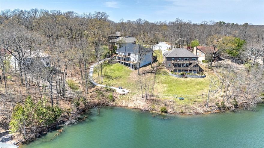 Welcome to your own slice of lakefront paradise on beautiful Lake Brittany in Bella Vista. This 5-bedroom, 3-bath home offers the perfect blend of relaxation and functionality with lake access directly from the property—just steps to the water for kayaking, fishing, or simply soaking in the view. Designed for comfort and flexibility, the home features two full kitchens, 2 living rooms, and 2 laundry rooms. Fantastic layout, ideal for guests, entertaining, or multi-generational living. Step outside to enjoy two expansive decks overlooking the lake, perfect for outdoor dining, morning coffee, or evening gatherings. Recent upgrades include a new AC unit March 2025 and a septic system pumped in 2024, giving you peace of mind and move-in readiness. Fenced in dog yard in the back! There's also a cozy outdoor fire pit—just one more way to enjoy the tranquil surroundings. With a strong short-term rental history, this property offers excellent income potential as well. Come see what lake life could look like for you!