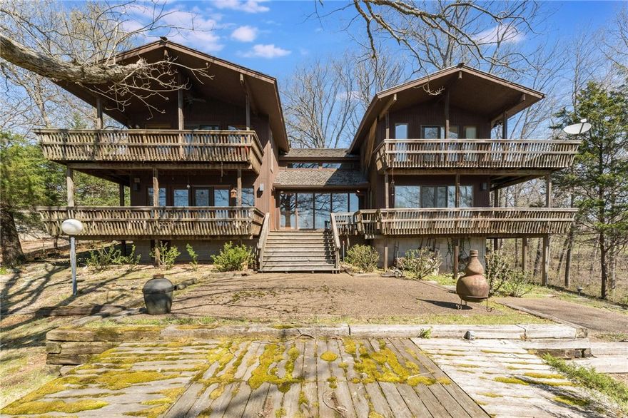 Perched above Lake Atalanta, this custom redwood home offers 4 bedrooms, 3 baths, and 2.24 wooded acres. Take in the views from two expansive decks or cozy up by the natural stone fireplace inside. Just steps from the park and bike trails, and minutes to downtown Rogers, it’s the perfect blend of nature and convenience—ideal as a full-time home, weekend retreat, or short-term rental.