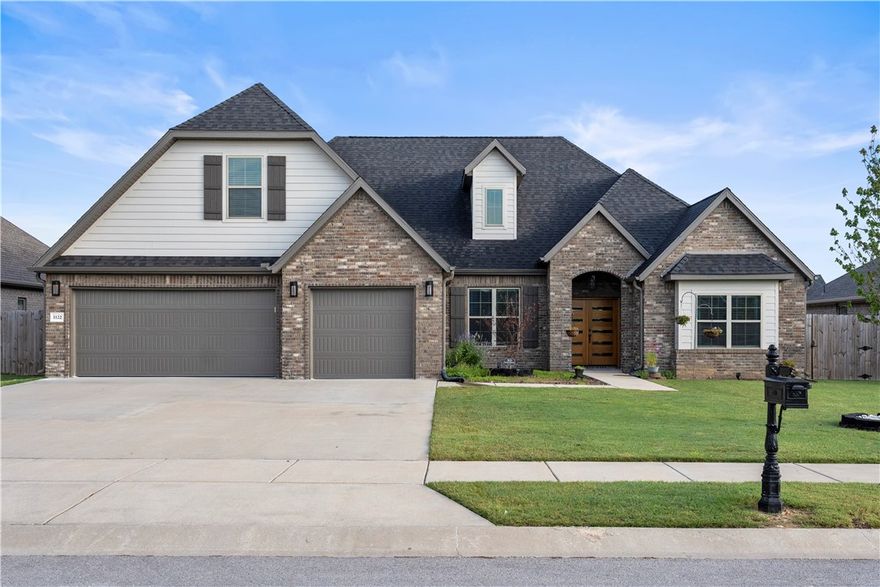 Welcome to 1122 Giulia Ave. Built in 2023 on a 0.27-acre lot in Tontitown’s premier South Pointe community. This is the only plan of its kind in the neighborhood. Step inside to vaulted ceilings, elegant French doors, and a bright open layout with a cozy corner fireplace. The chef’s kitchen features custom cabinetry, a large center island, and seamless flow into the spacious dining area — perfect for entertaining. The primary suite and guest room are conveniently located on the main floor, along with two bedrooms that share a Jack-and-Jill bath. A dedicated office is set just off the entryway. Upstairs, enjoy a fifth bedroom, full bath AND media room/6th bedroom, ideal for a second living area, home theatre or multi-generational living. Outside, relax under the covered patio with outdoor fireplace and TV hookups, or enjoy the neighborhood pool and pavilion just down the street.