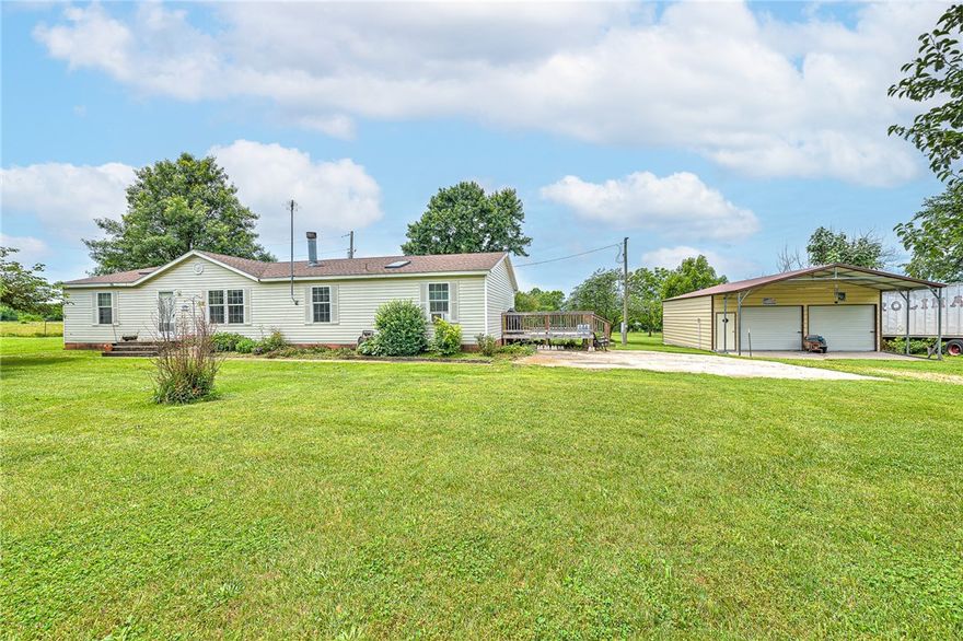Magnificent 5 acre m/l.  Fruit trees, apple, pecan, walnut, pear... Beautiful tree lined driveway. Country living at its best. Newer shop building with concrete floor, and electricity. In the county just on the west side of Cave Springs. Well water with city waterline run to the house just needs meter. Level land with plenty of room for another house or 3, cows, horses, etc. Bentonville schools! Manufactured home on permanent foundation, attached to land. Home has 6" exterior walls for lower energy bills. The property is also listed as land MLS#1278937