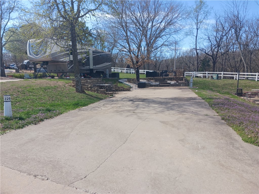 This back in lot could be called one of the largest lots available in the RV resort for both useable space and entertainment value! Lower patio will have you falling in love with views and fun of haggling your neighbors as they pass by on evening strolls. The Upper patio is one that will be for favored by fur babies, little ones and that grill loving person in your life. Outdoor kitchen with water, offers a fully fenced area and plenty of room for patio furniture. The Lot will accommodate a 45 ft 5th Wheel trailer - not only does it fit nicely but it also allows plenty more space for additional parking.