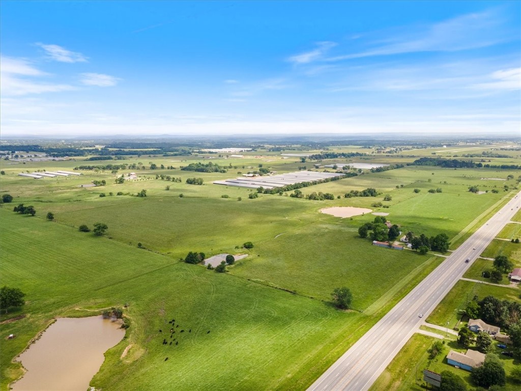 This 92.86-acre property offers numerous development possibilities, leveraging its prime location along a major highway. Onsite natural gas and Siloam water across Hwy., Gentry water located at Shady Grove Rd. The fenced and cross-fenced pasture, complemented by ponds, makes it ideal for livestock or other agricultural uses. Includes a hay barn and outbuildings (though they are of no significant value). The property is divided into two parcels: 55.49 acres (18-13911-000) and 37.37 acres (18-13997-000), with the owner open to selling them individually for a negotiated price. This flexibility allows for tailored investment opportunities, whether in agriculture, residential development, or other commercial enterprises.
