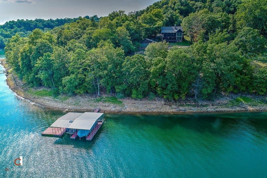 SPECTACULAR LAKEFRONT LUXURY CABIN-LIKE RETREAT WITH 3 LEVELS, DETACHED HEATED/COOLED PAVILION W/ FIREPLACE, 3 CAR GARAGE, DOG KENNEL, AND PRIVATE 2 STALL BOAT DOCK WITH SWIM DECK all on just over an acre setting!  Remodeled to perfection in 2015 with amazing amenities both inside and outside!  Beautiful pine wood flooring, rock wood burning fireplace, high vaulted tongue and groove and beamed ceilings, stainless appliances, charming loft, main level master retreat, fabulous screened deck, huge walk-out basement with bonus room and large covered deck!  Private well w/ salt & peroxide system and additional filtering system.  YOUR DREAM LAKE HOME AWAITS!!