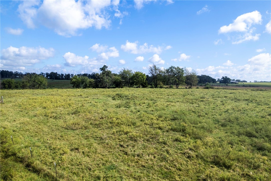 Beautiful 7.5 acres in Bentonville that’s mostly flat, cleared, and build-ready. A pond and barn convey, offering immediate utility for storage, animals, or future hobby-farm plans. Plenty of room for a custom home, shop, and outdoor living while keeping wide-open views. You're less than 20 minutes from XNA and downtown Bentonville, this is for sure a property to see! This tract is being split from a larger parcel - final acreage and property boundaries are subject to change upon completion of the new survey and any required approvals. Any boundary lines shown in marketing are approximate. The property is currently on a well; public water is located across the road and may be connected with City approval.