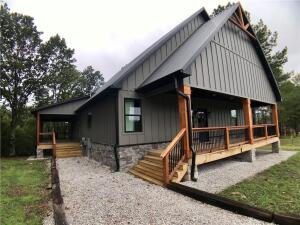 Located on the Kings River just 15 minutes from downtown Eureka Springs. Serene & peaceful this majestic cabin has views of the Kings River and so much natural light. The kitchen is equipped with a 5 burner commercial range, oversized island with marble counter tops, and pass through windows to outdoor seating! In the living room you will find the grand fireplace, vaulted pine ceiling, and views, views, views! On a cool night, relax outside with the outdoor fireplace on your wrap around deck gazing at the river! Downstairs the primary bedroom has a walk in closet, large bathroom with a soaker tub & oversized walk-in shower. On the other side you'll find 3 additional guest rooms and two full baths. Upstairs there is a loft that can be used for lounging, gaming, or sleeping.