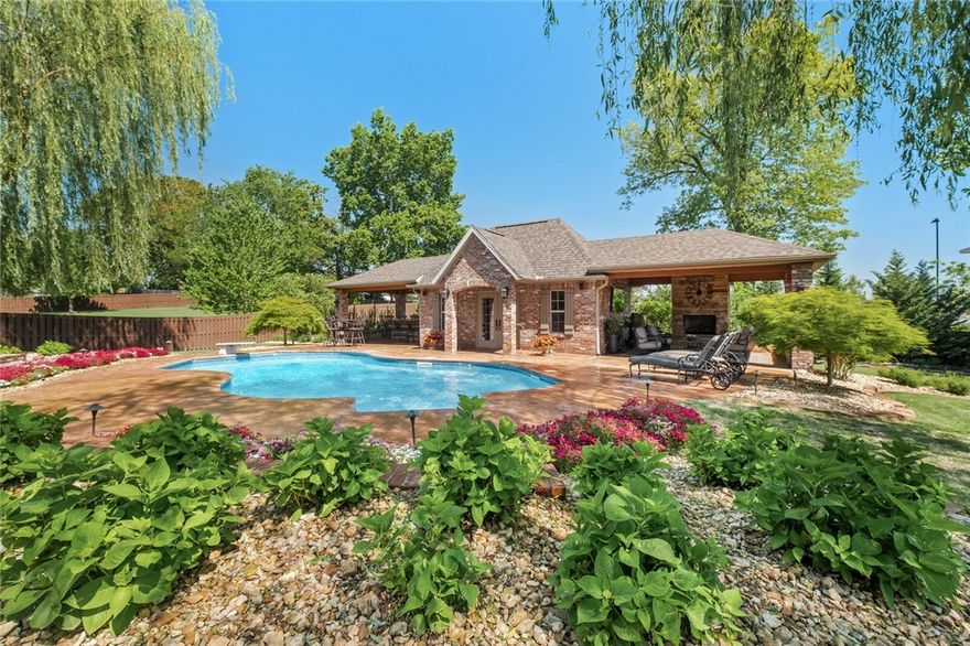 Framed by a canopy of mature trees & lush manicured lawn, this stately home perfectly embodies style & elegance in sought-after Manors neighborhood. A long list of rich architectural details including arched doorways, hardwood flooring, detailed millwork & designer finishes all add to the homes graceful appeal. Gorgeous French doors lead to a grand foyer that connects oversized living spaces, ideal for entertaining. The chef's kitchen highlights include custom cabinetry, granite countertops, exposed brick, spacious island, professional appliances, separate beverage cooler & walk-in pantry. This spacious & open floor plan features 5 bdrms, 3 full baths, 2 half baths, 3 living areas, bonus room & media room. Wonderful outdoor spaces include covered patios and a separate pool house with 2 covered lounges, outdoor fireplace & built-in grilling kitchen- all overlooking the stunning inground heated pool with fountains. This is a rare opportunity to own your very own oasis in the best location Rogers has to offer! 
.