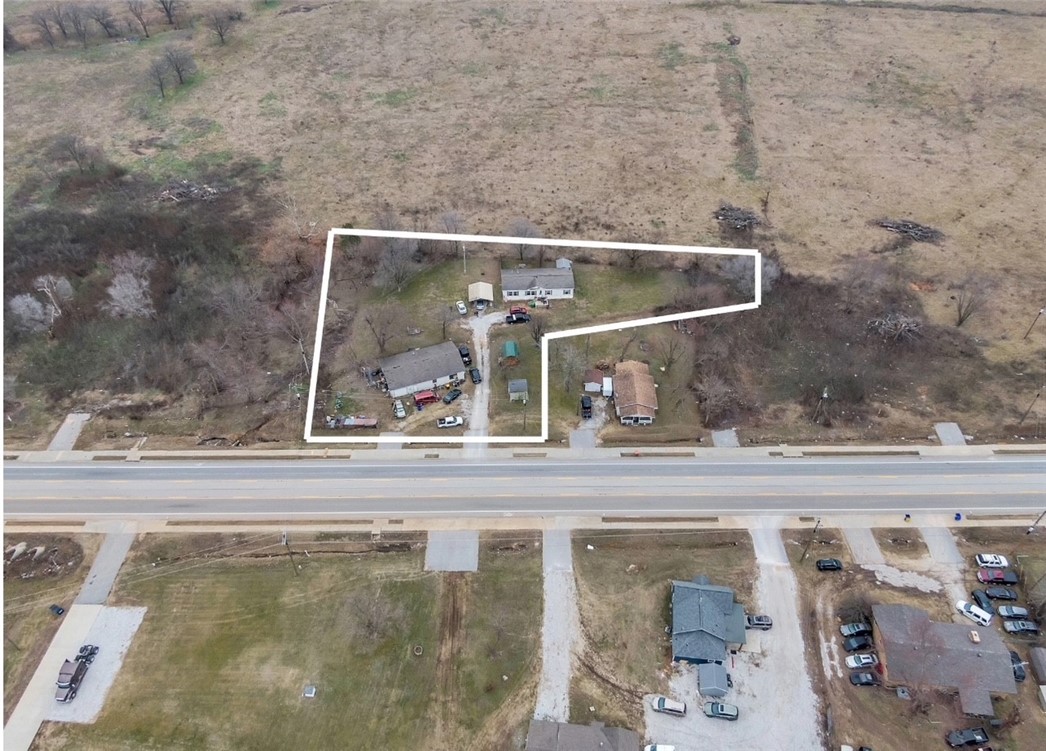 Looking for commercial property for a gas station, car lot, office space or flex space? This property is zoned commercial and has almost 160 feet of frontage on Arkansas Highway 265, with a daily traffic count of nearly 20,000 vehicles a day. There is residential development taking place to the East, West and North of the property and the new 612 bypass will sit less than 3/4 of a mile to the South. Fortune 500 member J.B. Hunt has their world headquarters just 2.8 miles away. The opportunity to build your business with tremendous future growth has never been greater than here.
The home on the front is revenue generating and the mobile home on the back conveys unless the buyer wants it removed. The barns in the front and back of the mobile home do not convey.