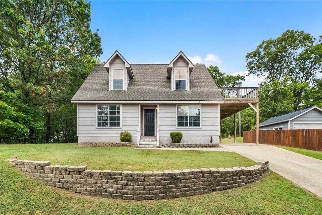 Enjoy the peaceful Bella Vista setting with this charming home surrounded by trees, just minutes from trails, lakes, and local conveniences. The main level offers a cozy living room with a detached electric fireplace that conveys, an open kitchen and dining area with a pantry and brand-new microwave, a laundry room, and the primary suite. Upstairs features two bedrooms, one with deck access, and a full bath. Step onto the deck to take in the wooded views, with a covered carport below for convenience. The roof was replaced within the last five years for added peace of mind. Perfect for outdoor enthusiasts, this home is just 1 minute from the Tweety Bird Bike Trailhead, 6 minutes from Lake Windsor, 11 minutes from Lake Avalon, and only 4 minutes from the future OZ Trails Bike Park with lift access. Grocery stores, restaurants, and the Bella Vista Recreation Center are close by, with quick access to I-49 for an easy commute.