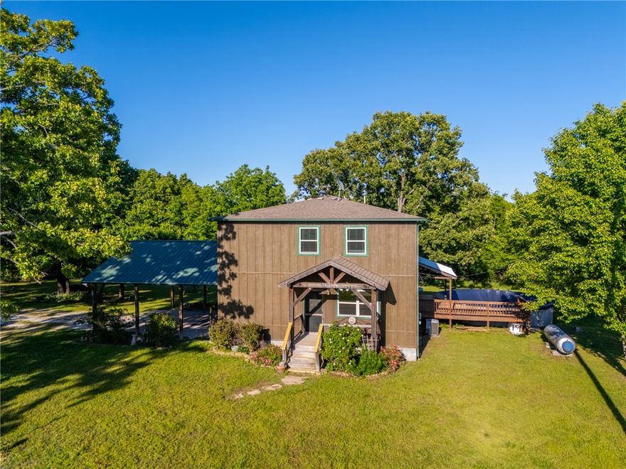 Peaceful country living on 2.6 private acres just minutes from Harrison amenities. This one-owner custom-built home, completed in 2014, offers 4 bedrooms, 3 full baths, quality craftsmanship, and a beautifully maintained setting surrounded by mature trees (plus cherry trees & blackberry bushes) & open usable land. The spacious open-concept layout features custom cabinetry, hand-poured stunning resin countertops, abundant natural light, and warm custom finishes throughout. The oversized primary suite includes a custom tile walk-in shower and massive walk-in closet, while 2 other upstairs bedrooms share a functional Jack-and-Jill bath. Enjoy outdoor living with a screened-in porch featuring a stunning stone fireplace, covered deck overlooking the inground pool, fire pit area, tire swing, and park-like yard. The shop includes white concrete floors, a whole wall of cabinets, enclosed office/storage space, and attached lean-to coverage. Excellent internet available. Private well, septic, and owned propane tank included.