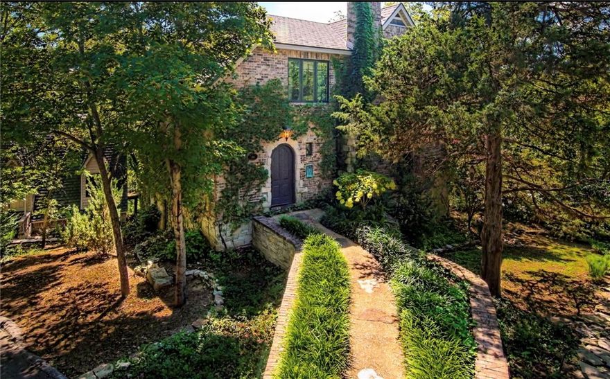 Fabulous hidden gem of a home with detached 1 BR/1 BA two-car garage and efficiency apartment, located within walking distance of the vibrant downtown restaurant and shopping district of Eureka Springs. This elegant brick home with limestone accents evokes a storybook feel, while the arched doorways, built-ins and living room fireplace continue the ambiance indoors. Thoughtful chef’s kitchen includes a casual dining area, adjacent to a light-flooded dining room.  Upstairs the Master Suite with gas fireplace and second bedroom/office are tucked comfortably under the eaves. Lower level has an additional third bedroom, full bath and laundry/utility room off a large family room which leads out to the patio with outdoor fireplace, grill and koi pond. Charming stone walls and walking paths wind through the property, which has four rare off-street parking spots in addition to the garage--making this home a "must-see."