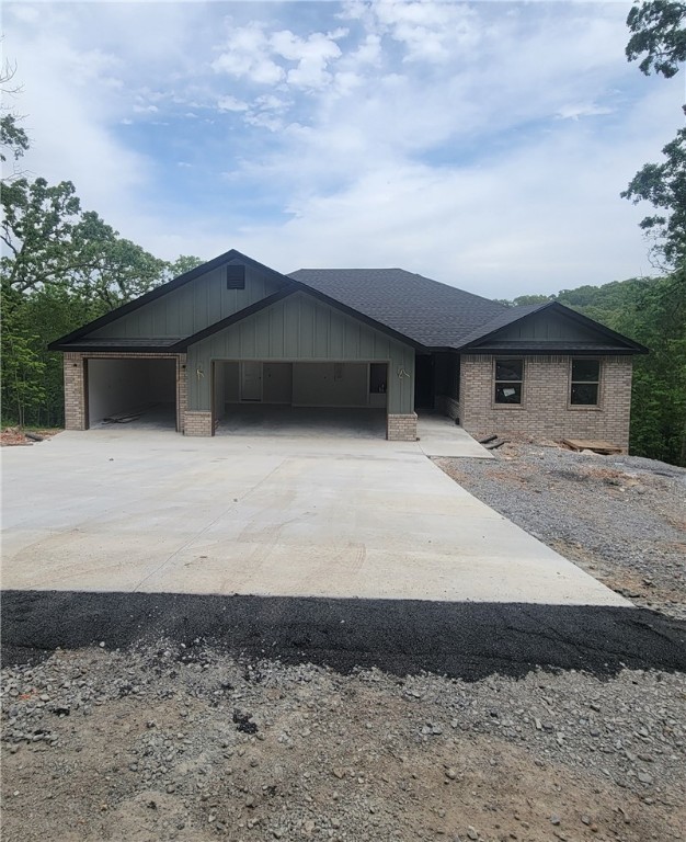 Take a look at this beautiful, brand-new home, tucked away among lovely trees in a peaceful setting! Inside, you'll find a spacious 1,806 square foot layout with three bedrooms and two bathrooms. The open-concept kitchen and living area invites you to gather with friends and family, complete with a vaulted ceiling and a warm fireplace. And with a roomy three-car garage, there's plenty of space for your cars and hobbies! You’ll be close to the Tunnel Vision bike trail and just a short drive from all the fun Northwest Arkansas offers. This home gives you the perfect mix of privacy and convenience!