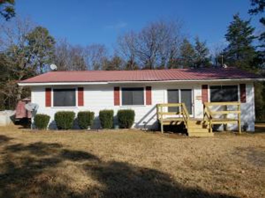 County home on 4 acres. About 1 acre cleared and 3 acres wooded. This home offers 3 bedrooms and 1.5 bathrooms and a nice open living, kitchen and dining area. There a large carport with the center being tall enough for a camper, 3 storage buildings, and 2 wells in addition to city water.