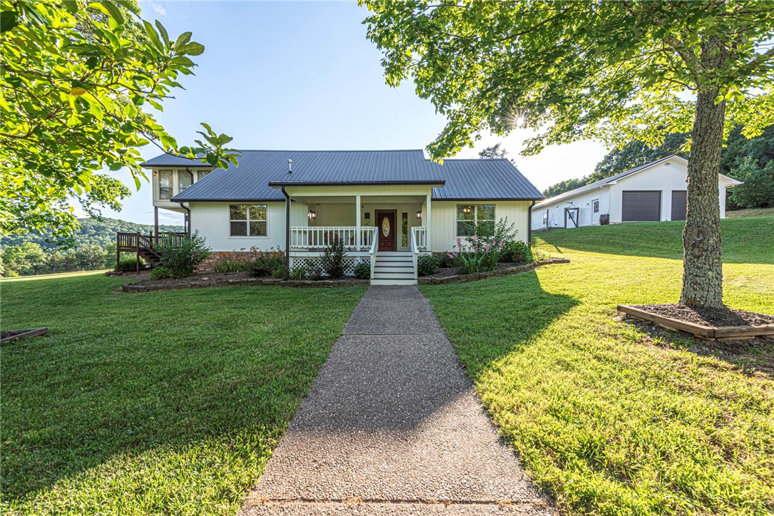This UPDATED 5 bd 3 ba home on 87.76 ac. w/ 5 ponds & 2 bd 1 bath apartment, is 20 min from University of Arkansas & all the city amenities your heart could desire—yet tucked in the countryside! From the covered front porch head inside to spacious living w/ wood flrs, formal dining rm, beautiful kitchen w/ stainless steel apps, butcher block island, new counters & tiled bksplsh 2nd living rm perfect for entertaining! 4 bedrms & 2 remodeled bathrms on main flr! Upstairs, retreat in the large primary w/ redesigned bathrm w/ double sink vanity, walk-in shower, & your own all-season rm w/ wood-accents & new sliding door to private upper-level deck! Head out to the newly replaced back deck overlooking lush pasture, stunning Ozark Mtns, & the stars that put on a show! 2 car detached garage w/ 2bd 1 bath apartment w/ covered porch, living, kitchen, dining & laundry hookup & new metal roof & fresh ext paint! Whether you’re dreaming of a homestead, hobby farm, or want space in the Natural State, this property delivers!