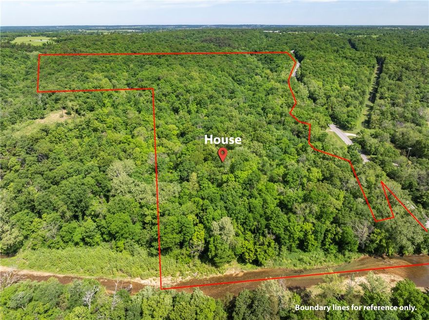 Located across the road from Rootville with frontage on Spavinaw Creek, this rustic, secluded cabin/house was built in the 1970s by the family who have owned this land for generations and the two story insulated metal outbuilding was added later. The 2 BR 2 BA house has electricity, septic, propane and a well on the property. The outbuilding could easily become a barndominium & is insulated with electricity.  The 69.65 acres of pristine woods, 600 plus feet of creek access just below the house sits amid mature woodlands and beautiful low cliffs and rock formations making it perfect for recreational use. This property is located next to a private hunting and fishing recreational facility.   The original concrete block house has a metal roof and is sturdy.  It could be a retreat cabin or become the beginning of an amazing larger home. You will want to see this for yourself. The lines drawn are not a survey but an estimation of property boundaries.