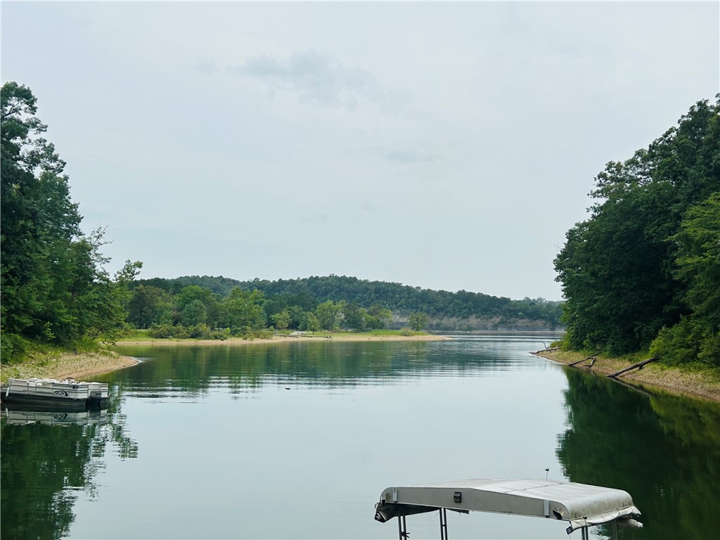 .75 acre Beautiful Beaver lake front property. 8 miles to 71 business. NO RESTRICTIONS , campers, tiny homes, mobile homes all allowed. Electric and septic system already installed, city water and Cox Cable on site. Property includes a 24 x 36 12 ft high metal covered concrete slab ready for your camper or motorhome to live on property while you build your dream home. Land butts up to the corp line with a short easy walk to the water. There is also access to lake by stairs and trail on the road. Horseshoe Bend Marina and Boat Launch 1 mile away.
Currently working on a plan to add 860+ sq ft tiny home with oversized 2 car carport that can be finished per buyers preference during construction leaving room to still build a 2-3 br walkout basement. Price will be effected based on stage of construction