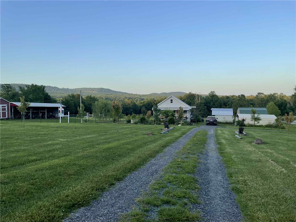 If youāve ever dreamed of a simpler lifeāwhere the sunrise greets you with birdsong, the sunset melts behind the mountains, and your animals graze peacefully in your own backyardāwelcome home. Tucked down a quiet dirt road just outside the friendly town of Marshall, this hilltop homestead blends modern farmhouse style with cottagecore charm, all set against breathtaking Ozark Mountain views. With fenced and cross-fenced pastures ready for horses, goats, or cattle, and open skies stretching in every direction, you can sip coffee on the spacious front porch, care for your animals with ease, and stargaze in quiet comfort. The beautifully landscaped yard features mature trees, flowering shrubs, and raised garden beds, complemented by a gravel driveway with ample parking. Two storage buildings and a pole barn with tack room provide plenty of space to safely store mountain bikes, kayaks, tools, and outdoor gearāperfect for exploring the rugged Ozark terrain. This is a property that feels like a page out of a storybook.