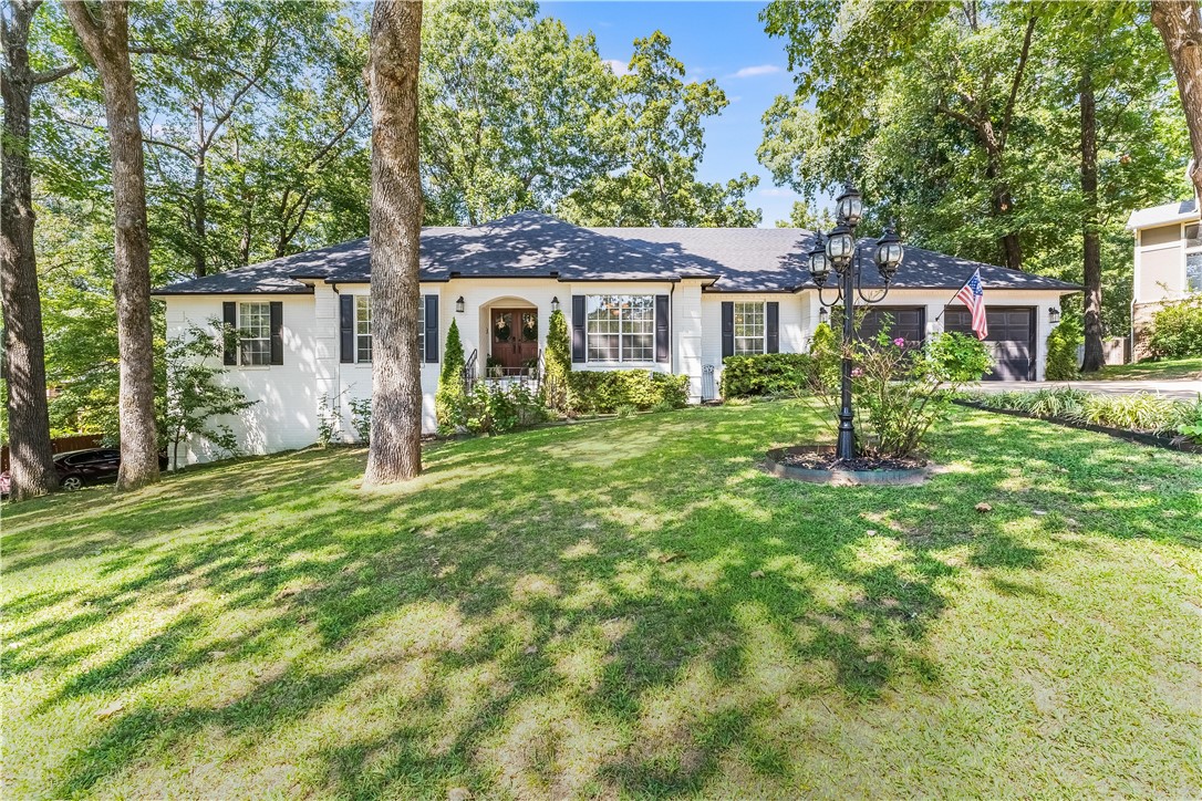 Welcome to this beautifully renovated home, where modern touches and thoughtful updates create a perfect blend of style and comfort. The freshly painted exterior, complemented by a new front door, immediately sets the tone for what awaits inside. The heart of the home is the updated kitchen, featuring new appliances, quartzite counters, freshly painted cabinets, and new backsplash. The entire interior has been freshly painted, and new light fixtures add an updated feel throughout. The spacious primary suite boasts new flooring, modern vanities, and a walk-in shower in the en-suite bathroom. For those seeking additional space, the finished walk-out basement provides endless possibilities, from a home office or gym to a cozy entertainment area. Additional updates include a new roof and HVAC system installed in 2018, along with a brand new sprinkler system. Nestled on a lot abundant with mature trees, the home offers a tranquil setting, yet it’s conveniently close to Lake Fayetteville, I-49, shopping, and trails.