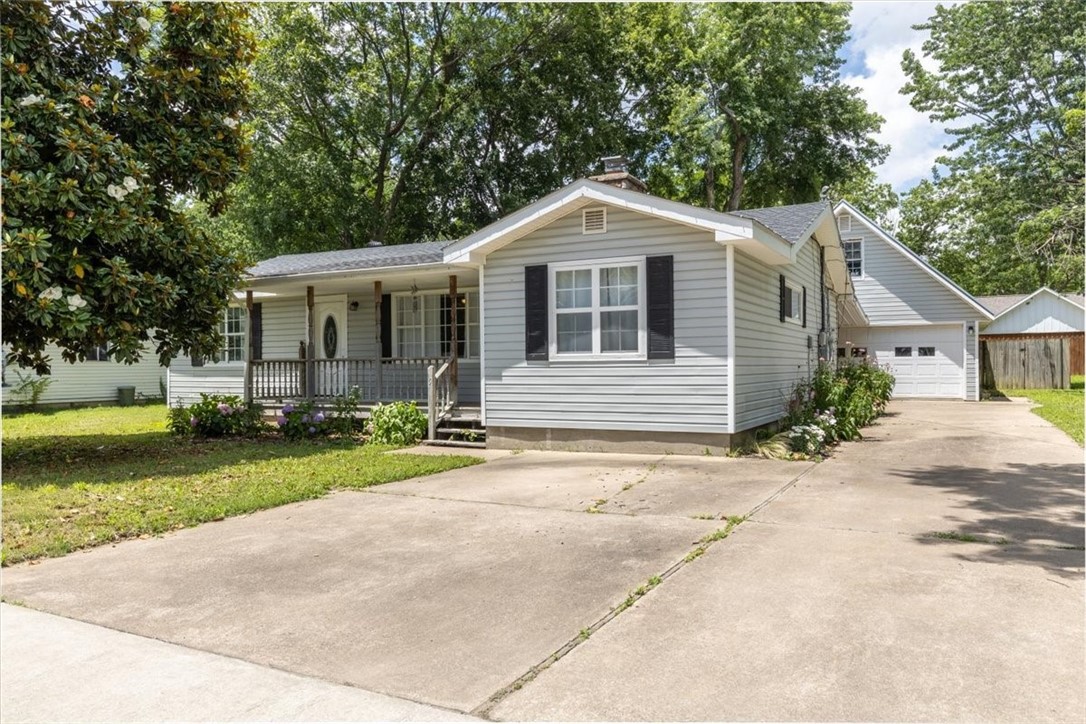 This beautifully remodeled ranch style home blends modern updates and charming features including a double sided, wood burning fireplace, and large open spaces with great natural light! Interior upgrades include paint, granite counters, remodeled bathrooms, laminate flooring, and newer appliances. You will also find a large fenced back yard, a covered front porch, and a detached oversized garage with an unfinished bonus room above!
