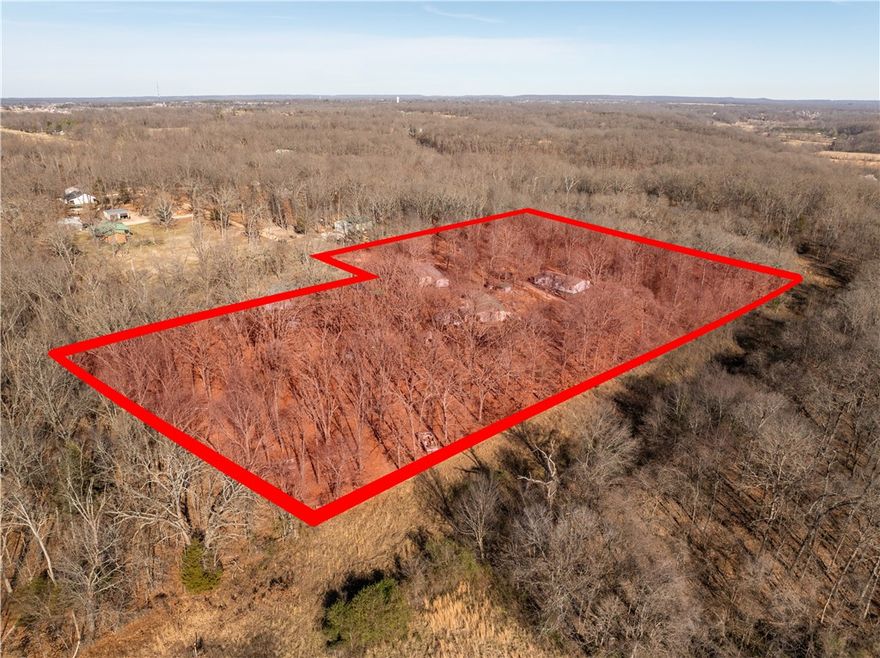 Here is your opportunity to own over 5  acres with a coveted Bentonville address—located outside city limits for added freedom and privacy. This property gives you the best of both worlds: a cleared section  for your home, while the rest remains wooded, creating a natural buffer and peaceful seclusion. You are at the end of a dead-end road and have plenty of privacy. Feed the deer and squirrels and watch the birds play all from your own home. There is a 1560 SF mobile home on the property that is included and sold as is. There are two other single-wide mobile homes that you will likely move off the property. There is a well house and other out buildings on the property for you. This acreage is situated close to Pea Ridge National Military Park as well as Beaver Lake, Lake Atlanta, and all the other amenities Northwest Arkansas has to offer. Come see this property today!