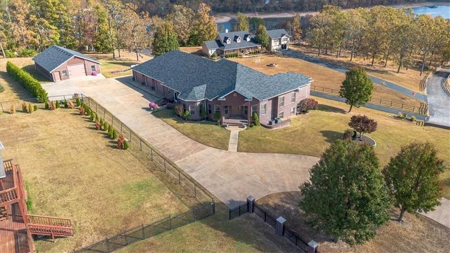 Nestled on 2.15 acres, this exquisite estate home in the coveted, gated South Mountain Estates on Beaver Lake exudes both luxury and relaxation! Whether you want to fish or swim off the private community dock (with boat slip/lift included), relax in the game room, or enjoy your morning coffee on the beautiful veranda overlooking the sunrise on Beaver Lake - this home has everything you need! The spacious kitchen with top of the line custom finishes and large living room connected to the outside veranda, offer the perfect setup for indoor/outdoor entertaining of friends and family. Huge workshop; With garage doors on both ends, this building is perfect to store all of your trailers and toys or your latest hobby.  Whole home generator that conveys.  All paved roads and less than 20 minutes to town.  Perfect combo of lake living with convenient shopping/restaurants close by! Four new HVAC Units less than 2.5 yrs. old; roof less than 2 years old.
View a special tour of this home here: https://vimeo.com/1100707636