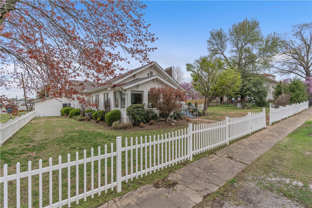 Looking for your own slice of Americana with the white picket fence you always dreamed of? This quaint, historic home gives you all the feelings of down home. Just a block off Main Street and located in the heart of Downtown you’re close to everything! The home features 3 bedrooms, 3 bathrooms, a home office and a sunroom to enjoy your morning coffee. Walk across the original hardwood floors in the living and dining areas or enjoy the heat from the new gas log fireplace. When Summer arrives enjoy your large pool with open air pool house or walk out your front gate and enjoy the fun at Kindley Park. Just down the street you can take advantage of all the Recreation Center has to offer. In the last 5 years the home has a new roof, new HVAC and new gas fireplace. From your front door you can be on the Walmart Home Office Campus in just about 20 minutes. Here’s your opportunity to have the best of both worlds. Small town charm while working on your big city dreams. Come see it today.