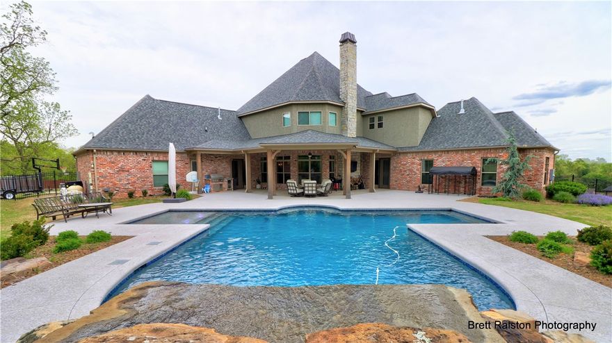 Wow!! Gorgeous custom build on 1.19 acres in Chattin Valley subdivision!! Large lot in a nice country setting close to some of the best schools in Bentonville! No details have been overlooked & you will feel the quality construction throughout the home. Beautiful private lot w/large saltwater pool & patio designed for entertaining. This resort style smart pool features a fabulous grotto waterfall, additional water features, lights, and built-in seating. Home features 4 bedrooms (all ensuite), 4.5 bathrooms, study, theater room & bonus room. The Luxury Master suite on the main level includes his & her closets. Additional guest bedroom and study on the main level. Open concept living/kitchen w/wood burning fireplace and great views of backyard oasis. Designer kitchen w/high end appliances & finishes-slow close drawers & loads of cabinet space. Custom mudroom and laundry room also feature top of the line finishes w/built in custom cabinetry & desk. Two attached 2 car garages, both extra deep. Storm shelter in garage.