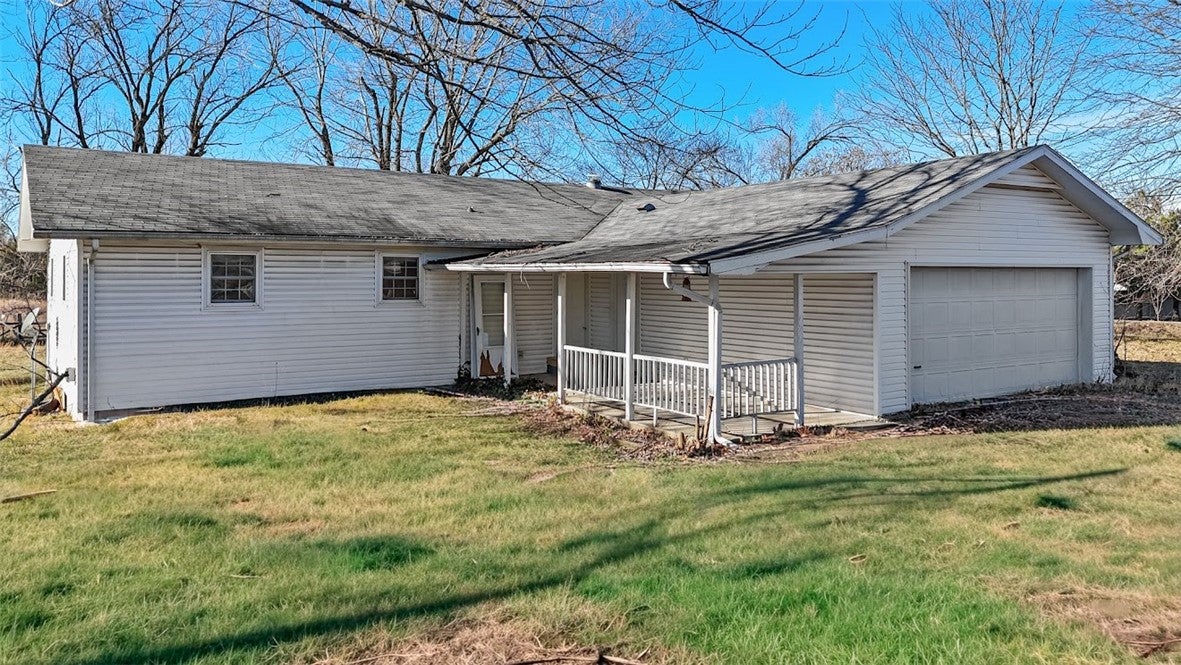 View of front of house featuring a front lawn, a g