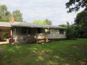 COUNTRY LIVING OFFERS WALKS WITH YOUR DOGS, QUIET TREE-COVERED LANES, A SLOWER PACE! Only minutes from town, this countrycharmer has lots of space including 2 family rooms. Newer, smooth top electric range, 2 skylights. Solid construction plus metal roof, screened porch, garden spots. Great family home or weekend getaway! Very pretty lawn