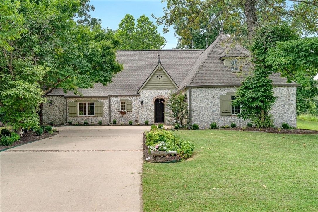 Check out this stunning French Country cottage in a gated community on a 0.48-acre lot, 5 minutes from downtown Rogers, Lake Atalanta, and Prairie Creek Marina. Its charming approach, with a stone and brick front exterior and a newly landscaped yard, will immediately capture your heart. The exterior was painted in 2024. The steel-framed house features faux stucco walls, vaulted ceilings with beams in the great room, freshly painted doors and trim, an open floor plan, and a wood-burning fireplace (firebox replaced 2025). Hardwood floors run throughout, tiled floors in the primary and a guest bedroom. Enjoy low utilities with styrofoam-insulated walls and high-efficiency HVAC (2023). The roof, gutters, windows, and doors were updated in 2017. A newer storage shed was added in 2021. The open kitchen has undercabinet lighting, a convection oven, a new garbage disposal (2025), and a new microwave (2022). Wired for security. Washer, dryer, and fridge convey. Priced below July 2025 Appraisal! Come see this custom home.