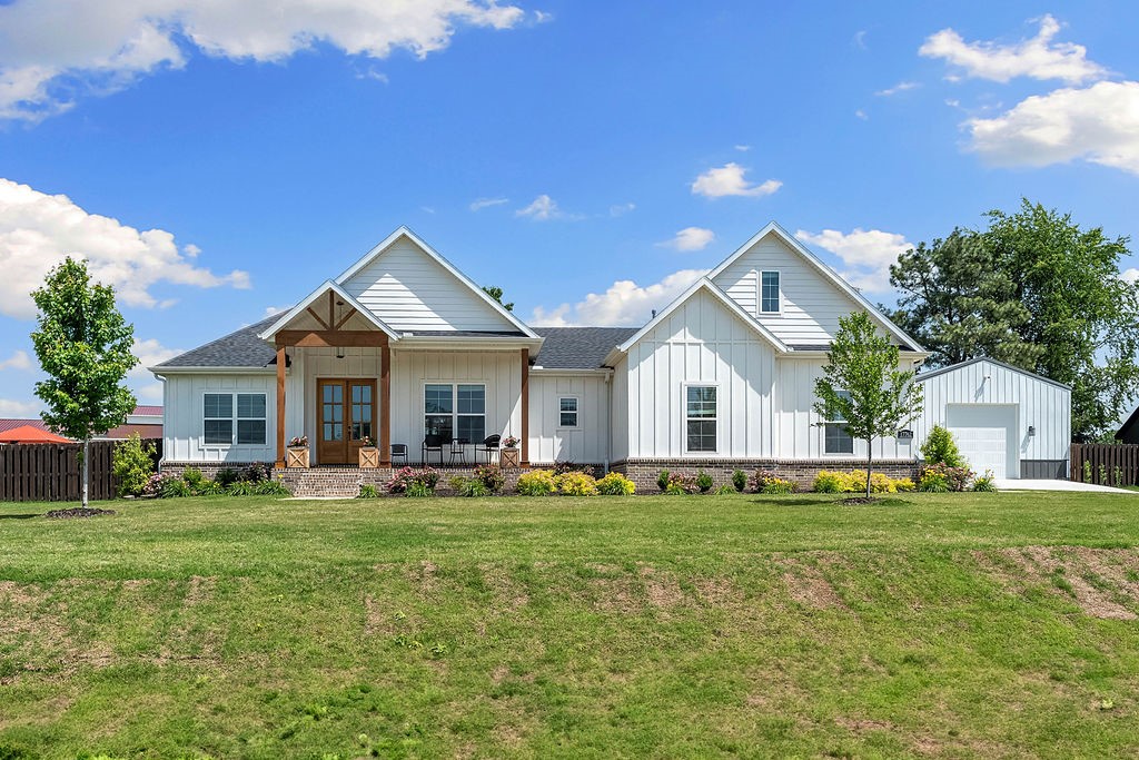 Your dream home sits on a large .85 acre lot and features a 576 SF detached garage/workshop. Detached garage could easily become a MIL quarters with 6" thick spray foam insulated walls, covered porch with hot tub and a 10 foot door for small RV. Landscaping is absolutely breathtaking surrounding the entire home. Enjoy the covered front porch then open front door to wide plank wood flooring, formal dining, soaring ceilings with beams, floor to ceiling brick fireplace and wall of windows flooding natural light throughout open living room. All opens to modern kitchen featuring a splash of white on everything with stainless appliances, gas range, nook and huge walk-in-pantry. Large primary has ensuite with dual vanities, tile shower, stand alone tub and walk-in-closet connected to laundry room! Two more large bedrooms and bath on opposite side and large 4th bedroom with ensuite upstairs. 31x31 garage with mud area, tankless water heater and whole house Culligan water filtration/softener. Large fenced yard with pergula.