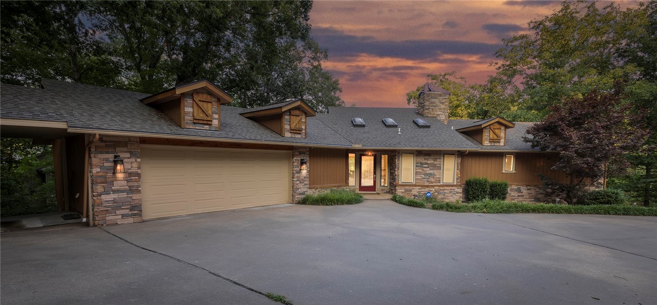 Park-Like, Secluded Lake-Front Living! 1.66 double lot with killer views and a private dock and covered boat lift. The oversized kitchen features granite counters, a double oven, gas cooktop, coffee station and massive amounts of storage. Throughout the upstairs, enjoy expansive lake views with 3 double doors accessing the deck and screened in porch. The upper living area has a propane fireplace while the lower level has a wood burning fireplace. In the primary bedroom + bath you'll find a private deck area, two walk-in closets, gorgeous marble double vanity, soaking tub, tiled shower and another walk-in closet. The laundry room has a sink with granite counters and even MORE storage. Downstairs you'll find 2 bedrooms, one full bath, and another living room/game room - the pool table conveys- and a wet bar to entertain your guests! Ice machine, sink + mini fridge in the downstairs bar convey as well. Brand new HVAC system in Jan 2024, Hot Water Tank 2019. New dishwasher in 2025. Lower level shop area + so much more!