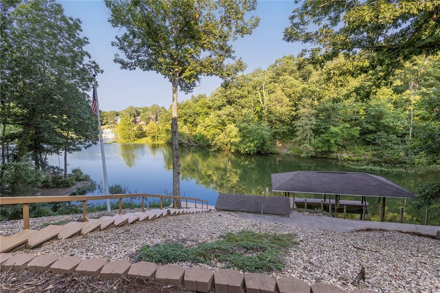Park-Like, Secluded Lake-Front Living! 1.66 double lot with killer views and a private dock and covered boat lift. The oversized kitchen features granite counters, a double oven, gas cooktop, coffee station and massive amounts of storage. Throughout the upstairs, enjoy expansive lake views with 3 double doors accessing the deck and screened in porch. The upper living area has a propane fireplace while the lower level has a wood burning fireplace. In the primary bedroom + bath you'll find a private deck area, two walk-in closets, gorgeous marble double vanity, soaking tub, tiled shower and another walk-in closet. The laundry room has a sink with granite counters and even MORE storage. Downstairs you'll find 2 bedrooms, one full bath, and another living room/game room - the pool table conveys- and a wet bar to entertain your guests! Ice machine, sink + mini fridge in the downstairs bar convey as well. Brand new HVAC system in Jan 2024, Hot Water Tank 2019. New dishwasher in 2025. Lower level shop area + so much more!