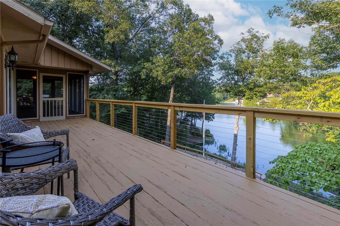 Park-Like, Secluded Lake-Front Living! 1.66 double lot with killer views and a private dock and covered boat lift. The oversized kitchen features granite counters, a double oven, gas cooktop, coffee station and massive amounts of storage. Throughout the upstairs, enjoy expansive lake views with 3 double doors accessing the deck and screened in porch. The upper living area has a propane fireplace while the lower level has a wood burning fireplace. In the primary bedroom + bath you'll find a private deck area, two walk-in closets, gorgeous marble double vanity, soaking tub, tiled shower and another walk-in closet. The laundry room has a sink with granite counters and even MORE storage. Downstairs you'll find 2 bedrooms, one full bath, and another living room/game room - the pool table conveys- and a wet bar to entertain your guests! Ice machine, sink + mini fridge in the downstairs bar convey as well. Brand new HVAC system in Jan 2024, Hot Water Tank 2019. New dishwasher in 2025. Lower level shop area + so much more!