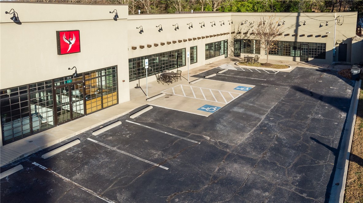 BACK ON THE MARKET DUE TO INDECISIVE BUYER.
Masterfully restored 1-Level building with striking finishes, high ceilings and an incredible amount of natural light. Located in the heart of Fayetteville with desirable College Ave frontage and accessibility, this property is a showcase for a national or regional headquarter company. Large glass walled conference room. Spacious reception area with functional built in storage and workspace. 12 private offices with 7 spaces for support staff. 4 handicapped accessible bathrooms. Executive office space with private reception and adjoining office for support person. 20 parking spaces. Building can be divided into two functional office spaces. Dropped Metalworks tin ceiling tiles and custom LED drop lights. Motion sensor light switches in offices. Centrally wired speaker system. Cat 6 cable throughout. Multiple HVAC zones.
Please visit the 3D Virtual Tour.