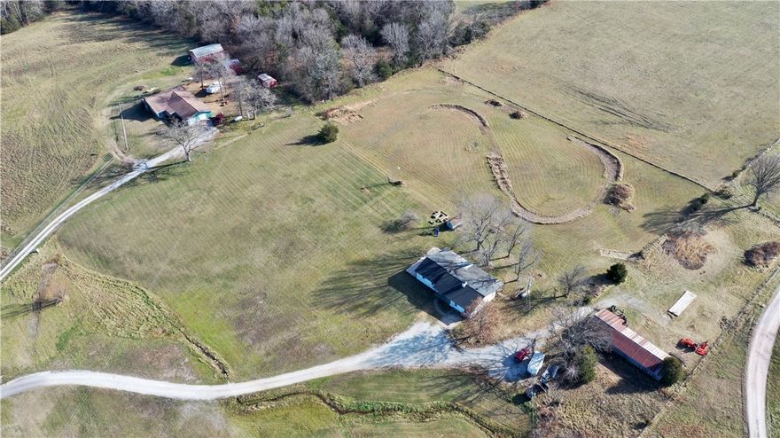 Back on the market at no fault of the home or Sellers! Appraisal in hand! Contemporary farmhouse charm meets hobby farm! This completely updated 3-bed, 2-bath home sits on 7.5 acres, just 4 minutes from Wal-Mart. The interior features a gorgeous kitchen designed to impress and will have you hosting every holiday this year! Dreamy primary suite with a spa-like bath, dual-head shower, and relaxing soaker tub. The walk-in closet feels straight out of a design magazine—stylish and functional. The mudroom is spacious and tucked behind custom cabinetry for a clean, seamless look. Outside features a powered pole barn with 110 and 220 amp bays, a dirt bike track, stunning sunsets, apple tree, wild blackberries, and raised U-shaped garden beds. There’s also a 50-amp RV site with its own septic and porch. Updates include HVAC, tankless water heater with scale inhibitor, PEX plumbing, Low-E windows, new gutters with leaf guard, and fireplace. Quiet acreage living with everyday convenience and style!