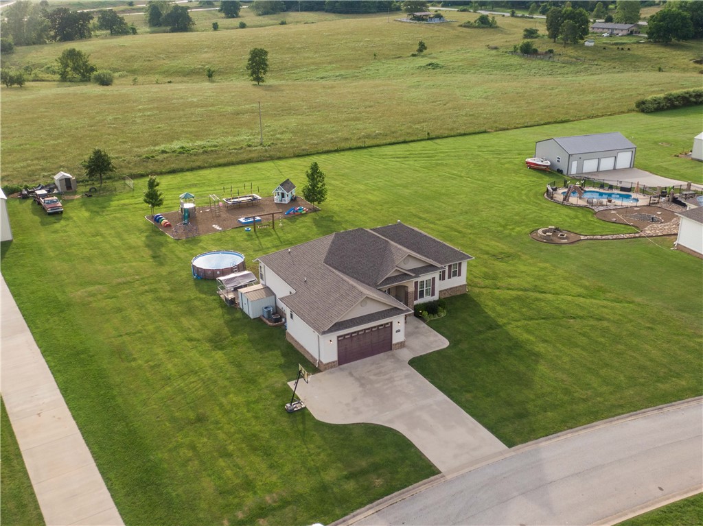 Looking for a serene and peaceful setting just outside the hustle and bustle of the city? This is it! This home sits on 1.01 acres and is impeccably maintained. Beautiful 4 bed 3 full bath home plus a home office is located just a quarter of a mile from the new I-49 interstate. This home offers granite countertops, stainless steel appliances, split floorplan, wood blinds, and so much more. The garage was converted to the 4th bedroom and has it's own entrance way as well. Gorgeous landscaping and curb appeal. No HOA on this one so you could have a small hobby farm, build a shop, or whatever your heart desires. This one is sure to impress at an affordable price! Schedule your showing today. Please note - the shed on the side of the home conveys. The small goat pen at the back of the property and playground equipment do not convey. The photo in some of the pics of the shop belongs to the neighbors.