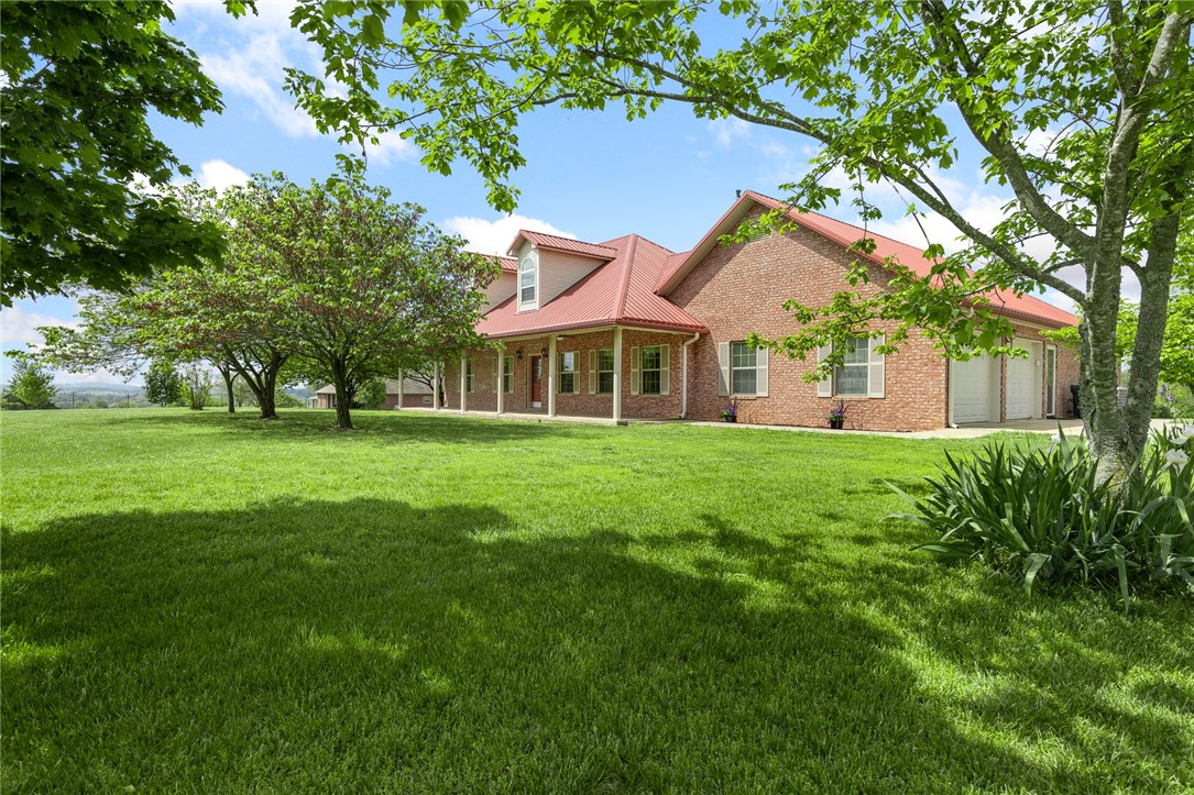 Spacious and full of potential, this 3,203 sq ft brick home sits on 4 acres in the heart of the Ozarks, with beautiful views of Boat Mountain. Located in Boone County, this property offers the best of country living while keeping you close to town. Inside, you’ll find 3 oversized bedrooms, each with its own private bathroom, plus a guest half bath. The kitchen is built for both everyday living and entertaining, featuring oak cabinetry, double ovens, and more storage than you could ever need. A formal dining room and large living area give you plenty of room to gather. The primary suite offers a huge walk-in closet and a jacuzzi tub for relaxing at the end of the day. Step outside to a massive back patio made for hosting, with views you'll appreciate year-round. A separate flex space is already in place—perfect for a guest suite or home office—offering endless possibilities to fit your lifestyle. There's also a greenhouse ready for your garden projects. Call today to see this immaculately maintained home.