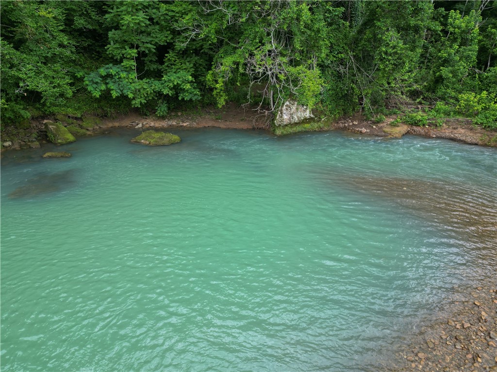 BIG PINEY CREEK frontage with your very own private swimming hole. WHAT A PIECE OF PROPERTY!!! This is a gorgeous 11 acres located in the Limestone Valley of Newton County, Arkansas. The natural beauty of this property is endless. This is the perfect escape for nature lovers, adventurers, or anyone seeking peace and quiet. At the heart of the property is a cozy 2-bedroom, 1-bath cottage perched above the creek, offering stunning views of the crystal-clear waters below. The cottage is serviced by spring-fed water, electricity, and internet, making it both comfortable and off-the-beaten-path. Wander the land and youāll discover a massive Indian rock overhang, cave, mature hardwoods, old fields and bluff scenery with direct access to the Ozark National Forest for endless exploration. Whether youāre looking for a weekend getaway, a basecamp for outdoor recreation, or a truly unique short-term rental opportunity, this one-of-a-kind property offers it all. Properties like this rarely come available.