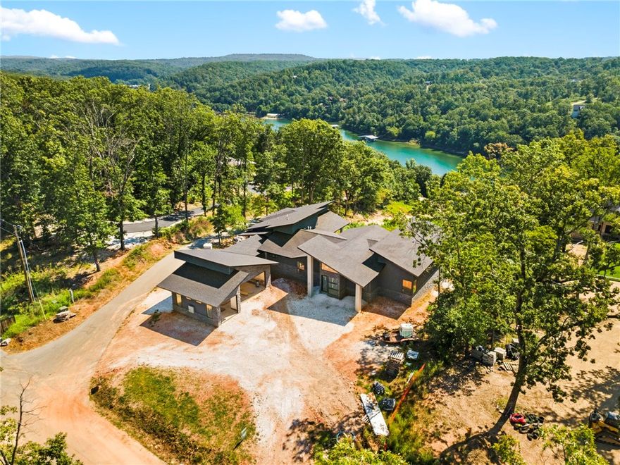 Imagine waking up to glass-framed sunrises over Beaver Lake, coffee in hand, while the water below mirrors the sky. Your day flows effortlessly from a swim in the luxurious pool to a quiet hour on the covered patio, then cocktails on the expansive decks as the horizon turns pink. This isn’t just a home; it’s a sanctuary where modern architecture and nature merge. Every detail is crafted for the way you actually want to live—whether that’s hosting fifty guests under soaring ceilings and firelight, or slipping away to your spa-inspired primary suite that feels more spa than residence. The chef’s kitchen becomes the stage for long, wine-fueled dinners with friends, while your private boat slip means spontaneous lake days are as easy as walking out your back door. At Hawks Landing, you don’t compromise—you curate experiences, you build memories, you claim a lifestyle where time slows and beauty is constant. This is not just buying a property; it’s investing in the version of yourself you’ve always envisioned.