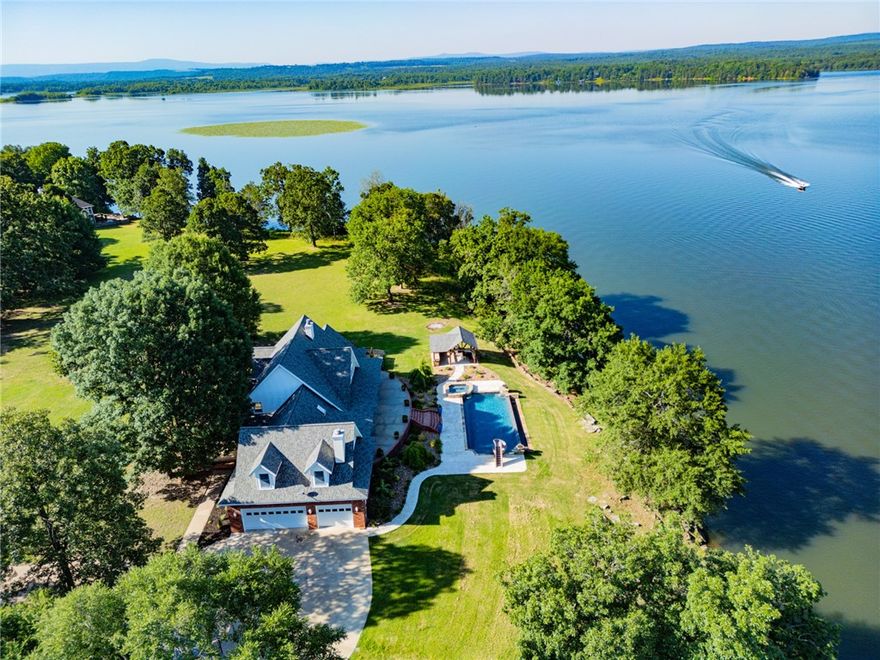 Welcome to your dream home on Piney Bay! This exquisite property boasts breathtaking panoramic lake views. As you step inside, you're greeted by a gorgeous foyer featuring marble flooring and a stunning chandelier. The kitchen is a chef's delight, equipped with a large island, custom cabinetry, granite countertops, a gas cooktop, and a double oven. Spanning over 4,000 square feet, this masterpiece offers a stunning balcony that overlooks the open kitchen and living room, which are bathed in natural light from abundant windows. The beautiful gas fireplace serves as a focal point, creating a warm and inviting atmosphere. The master suite is a peaceful retreat with amazing views, a luxurious bathroom, and a spacious walk-in closet.
