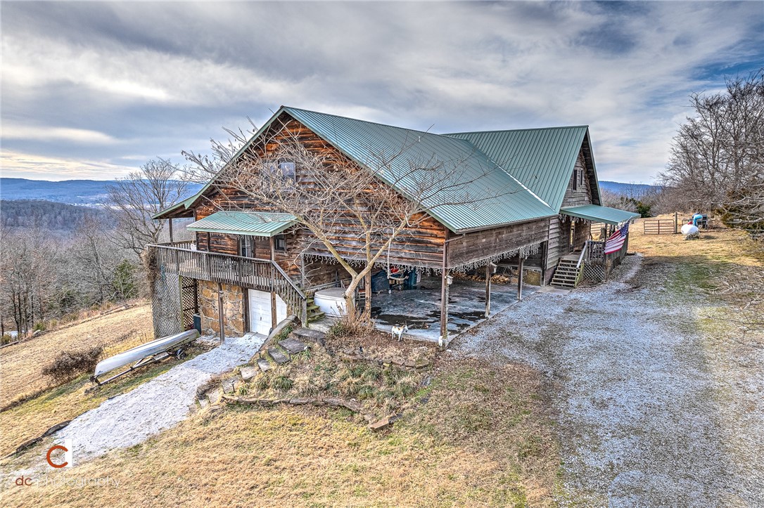 One of a kind cedar & stone home with incredible view. The main house is very open with wood vaulted ceiling and windows floor to ceiling. The guest house is connected by a breezeway and it has kitchen, eating area, 2 bedrooms and 1 1/2 baths. One car garage/workshop is heated & cooled 775 sq ft but not included in the square footage. The guest house has rented for $1,200 monthly and $169 on AIRBNB. Updates include: enclosing breakfast area into bedroom, cabinets in living area, roof, downstairs bathroom and utility room, total kitchen with new appliances and quartz countertops, tankless hot water heater, new supports under house & top windows sealed. With acceptable offer, refrigerators in main house and guest house will convey. Washer/Dryer in guest house will convey. You will feel like you're on vaction with wrap around deck and view.