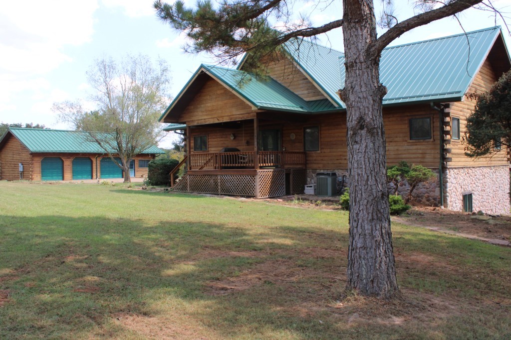 Terrific Log Home - 15 Acres on Crooked Creek - Plus 24x50 Garage/Shop Building!! See quality throughout this outstanding log home in beautiful setting overlooking Crooked Creek!! Features vaulted ceilings in entry & living area, wood stove with tall stone hearth, lots of wood interior & ceilings on main floor, kitchen with built-ins, large deck across back of home, 3 bedrooms, 2.5 baths, primary bedroom has patio door to deck overlooking meadow & creek, full bath with jetted tub & separate shower, full walk-out basement with huge 23x25 ft family room, home has over 3600 sq ft heated and cooled. Plus 24x50 ft detached log 3 car garage/shop building with full bath, 14x40 metal RV carport and enclosed 14x40 metal garage both on concrete slab. Land is mostly pasture with scattered trees, has over 900 feet of Crooked Creek frontage, plus frontage on Harmon Road and McDonald Road. Aerial map in Documents. Must See to Appreciate!!
