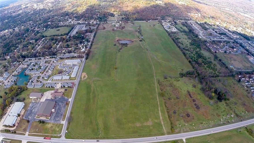 73 acre tract in city limits.  Ideal for development.  Close to University of Arkansas (2 miles).  Bordered by streets on 3 sides.  This acreage has 2,640 ft of frontage on Morningside Drive, 816 ft on E. 15th S, and 1,128 ft on E. Huntsville Road.  Property also includes a 1 1/2 story wood frame house with stone exterior that has 1724 sq ft of living space.  Additionally, there is a detached garage, barn and storage building.  All dwellings are being sold "as is".