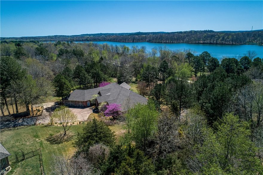 Executive estate on 2.91 acres (2 parcels) & pond near Springdale CC! Backs up to Lake Fayetteville Park & trails!  This custom built one level home boasts 10, 14, 15, & 17' ceilings.  Enjoy three large living areas, a wet bar, butler's pantry, stainless appliances, pantry, breakfast bar, double ovens, eat-in kitchen, gorgeous formal dining, 4 bedrooms, 4 baths, 2 fireplaces, & a 3 car garage with extra pad.  Master suite with fireplace, sitting area, private patio area, huge double closets, oversized walk-in shower, jetted tub, double sinks with makeup area, & separate water closet with bidet.  Second bedroom/office & bath on same end of house as master. Bathroom has door to outside, so it's ready for a pool out back!  Mother-in-laws suite with private bath & another bedroom & bath on opposite end of home. Two HVAC's, new roof in 2020, hickory hardwoods refinished in 2020, & surround sound throughout the house.